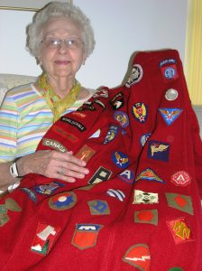 Marian Krinke holds the American Red Cross coat that she wore during her service in England during WWII.